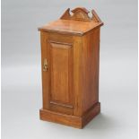 A Victorian walnut bedside cabinet with raised back enclosed by a panelled door, raised on a