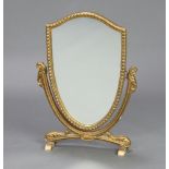 A Sheraton style shield shaped dressing table mirror contained in a gilt frame 49cm x 29cm x 10cm