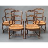 A set of 4 French carved elm ladder back carver chairs with woven rush seats raised on cabriole