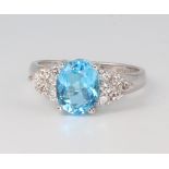 An white metal 14ct oval blue topaz and diamond ring, the topaz approx. 3.1ct, the diamonds