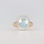 A 14ct yellow gold oval aquamarine and diamond cluster ring, size Q 1/2, 18 diamonds each at 0.03ct,