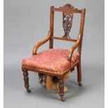 A Victorian mahogany slat back nursing chair with over stuffed seat raised on turned supports 82cm h