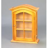 A walnut finished arch shaped display cabinet fitted shelves enclosed by a glazed panelled door 52cm