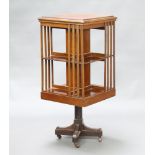 An Edwardian square oak revolving bookcase raised on a cruciform base 105cm h x 47cm w x 47cm d