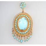 A yellow metal stamped 750, Egyptianesque pendant set with an oval cabochon turquoise and