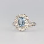 A white metal stamped plat oval aquamarine and diamond ring, the centre stone 1.1ct surrounded by