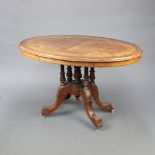 A Victorian inlaid quarter veneered snap top oval Loo table raised on 4 turned columns with