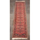A tan ground machine made Afghan style runner with 13 stylised medallions to the centre, 346cm x