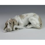 A Lladro figure of a reclining hound 24cm This lot is in good condition and is of first quality.