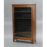 An Edwardian walnut display cabinet, the interior fitted adjustable shelves enclosed by a glazed