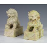 A pair of carved soapstone figures of Shi Shi raised on rectangular bases 12cm