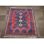 A blue and red ground North West Persian rug with 4 diamonds to the centre within a multi row border