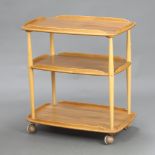 An Ercol light elm 3 tier tea trolley 76cm h x 71cm w x 46cm d Some contact marks and scratches in