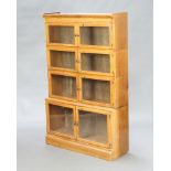 A light oak 4 tier Minty style bookcase enclosed by panelled doors 141cm h x 89cm w x 28cm d Water