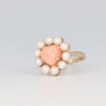 A 9ct yellow gold coral and seed pearl ring, the heart shaped coral 8mm x 9mm surrounded by 10