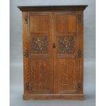 A 19th Century Continental carved oak wardrobe with moulded cornice enclosed by panelled doors