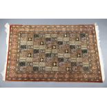 A North West Persian brown and green ground silk carpet, the central field having 66 rectangular