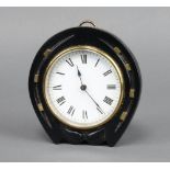 An Edwardian Continental timepiece with enamelled dial and Roman numerals contained in a carved