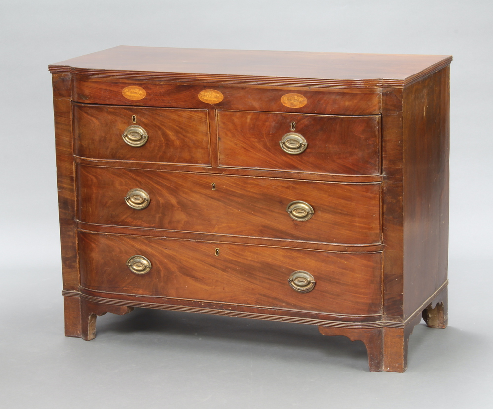 A Georgian inlaid mahogany bow front chest of 2 short and 2 long drawers with brass drop handles,