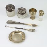 An Edwardian silver mounted glass scent rubbed marks, an egg cup, ashtray and 2 lidded jars,