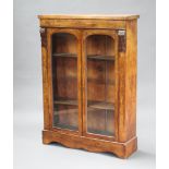 A Victorian inlaid walnut display cabinet fitted shelves enclosed by arched glazed panelled doors,