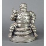 A Michelin figure of Bibendum sitting on 2 tyres 22cm x 17cm (possibly missing spanner to raised