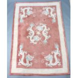 A peach ground Chinese carpet with dragon decoration and Grecian key border 277cm x 185cm Slight