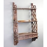 A bleached mahogany Chippendale style 3 tier hanging wall shelf with fret work panels to the side,