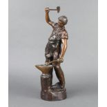 A late 19th Century bronze figure of a standing blacksmith an at anvil, indistinctly signed 39cm h x