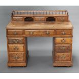 A Victorian light oak Dickens style desk having a raised superstructure to the back with 3/4