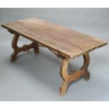 A Spanish style beech refectory dining table, raised on shaped supports with iron stretcher 74cm h x