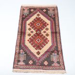 A brown and blue ground belouche rug with diamond shaped medallion to the centre 150cm x 85cm