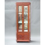 A 20th Century Chinese hardwood display cabinet with mirrored back fitted and adjustable shelves