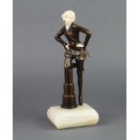 An Art Deco style bronze and resin figure of a lady standing by a pedestal, raised on a