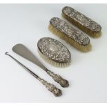 A silver backed hairbrush Birmingham 1975, 2 other mounted clothes brushes, a silver button hook and