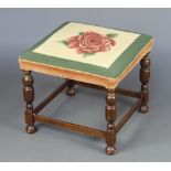 A 1930's, 17th Century style, square stool with Berlin woolwork seat decorated a rose, raised on cup