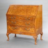 A 1950's Queen Anne style bureau with quarter veneered fall front above 3 drawers with brass swan