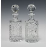 A pair of circular cut glass spirit decanters and stoppers 24cm