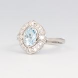 A white metal stamped Plat oval aquamarine and diamond ring, the centre stone 0.7ct, the brilliant