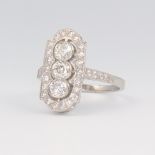 A white metal stamped Plat up-finger diamond ring with 3 diamonds surrounded by brilliant cut