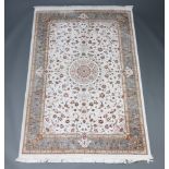 A white and green ground North West Persian floral patterned silk rug with central medallion