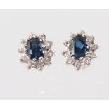 A pair of white metal stamped 18ct oval sapphire and diamond ear studs 10mm x 8mm, 2.2 grams