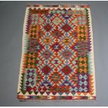 A green, orange, white and blue ground Chobi Kilim rug with all over geometric design 153cm x 100cm