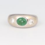 A white metal stamped 585 emerald and diamond gypsy set ring, the emerald approx. 1ct, the 2