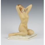 A Royal Dux matt figure of a seated naked lady wearing a floral head scarf on a triangular base