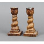 A pair of 1930's oak spiral turned candlesticks, raised on square bases 16cm h x 7cm