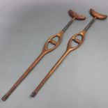 A pair of sprung loaded mahogany leather and metal crutches 124cm h x 21cm w x 4cm dLeather to one