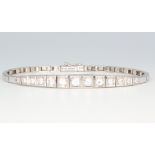 A white metal stamped 750 graduated 13 stone diamond bracelet, approx. 1.5ct, 17.5cm in length 14.