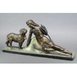 After Props Peccole, a plaster Art Deco figure of a recumbent lady skier with standing St Bernard