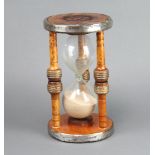 A wooden and glass hour glass formed from spinning shuttles 26cm h x 14cm diam